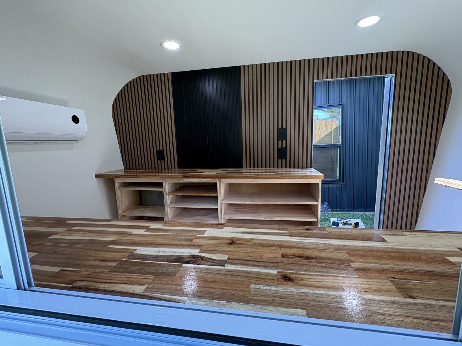 Black Barn Bakery interior with a curved wood slat wall, black center panel, and open door