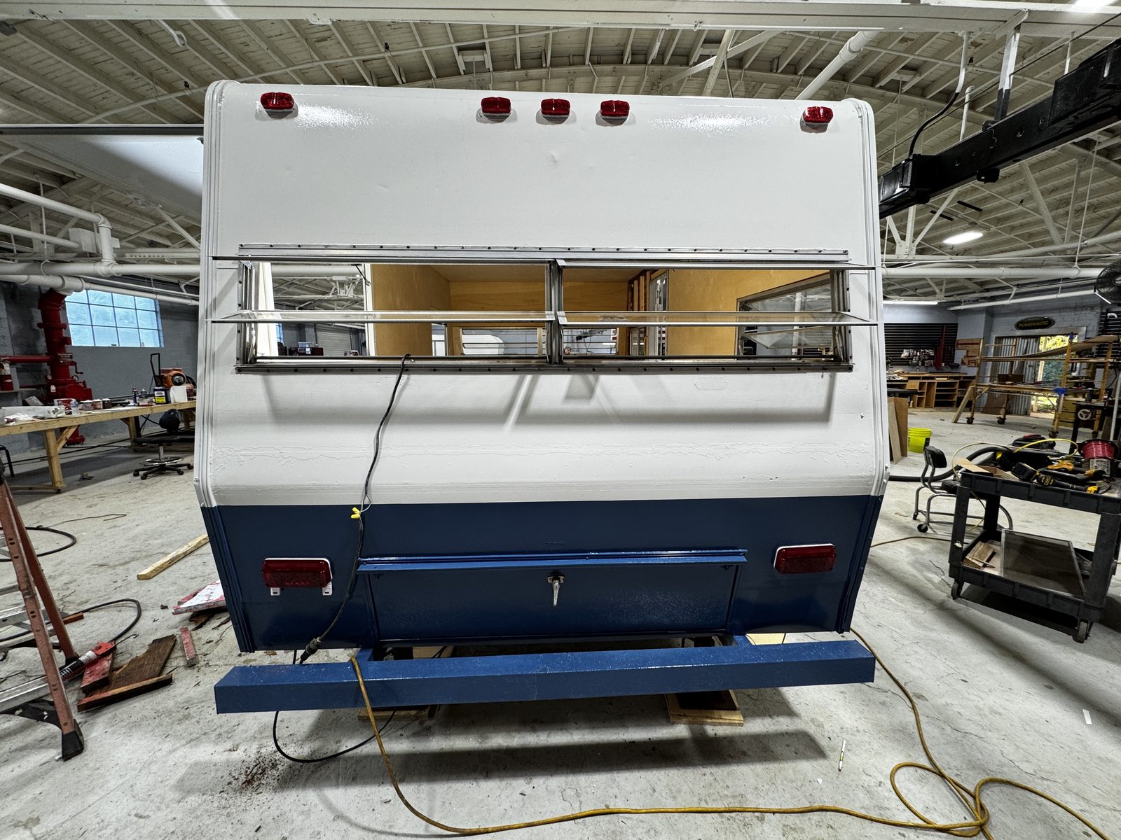 Rear of the white-over-navy trailer with the louvered window open