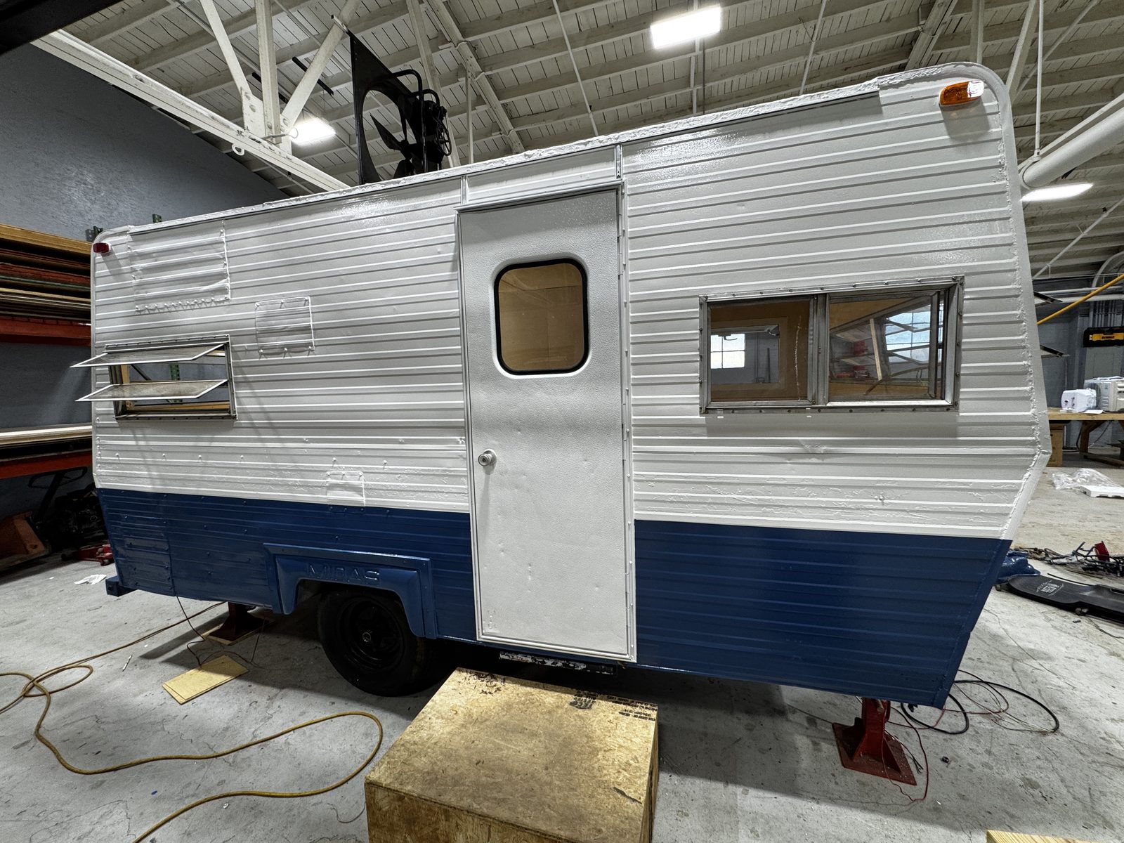 Door side of the white-and-navy trailer in the shop