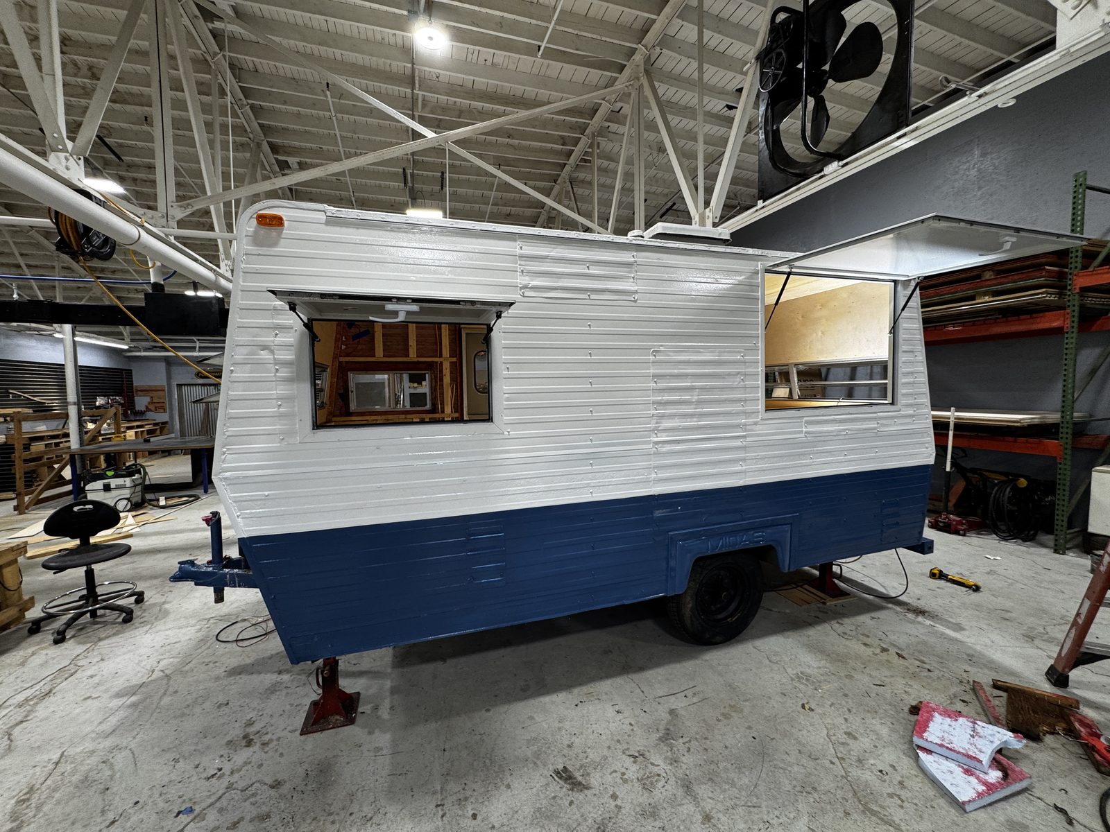 Side of the white-over-navy trailer with two hatches open and an embossed MIDAS badge